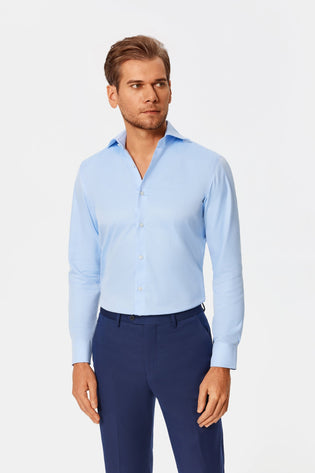 Model wearing a light blue Duke shirt with navy trousers.